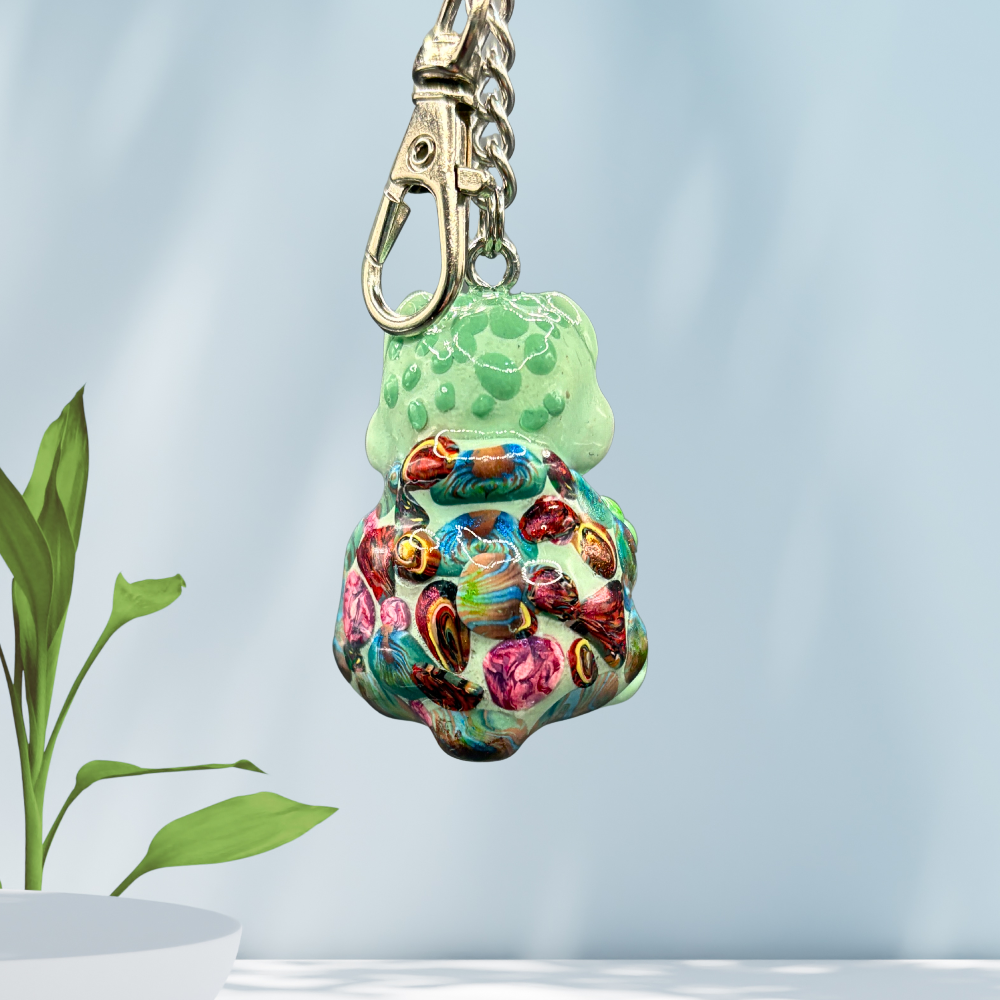 Cute baby sea turtle holding a purple heart keychain.