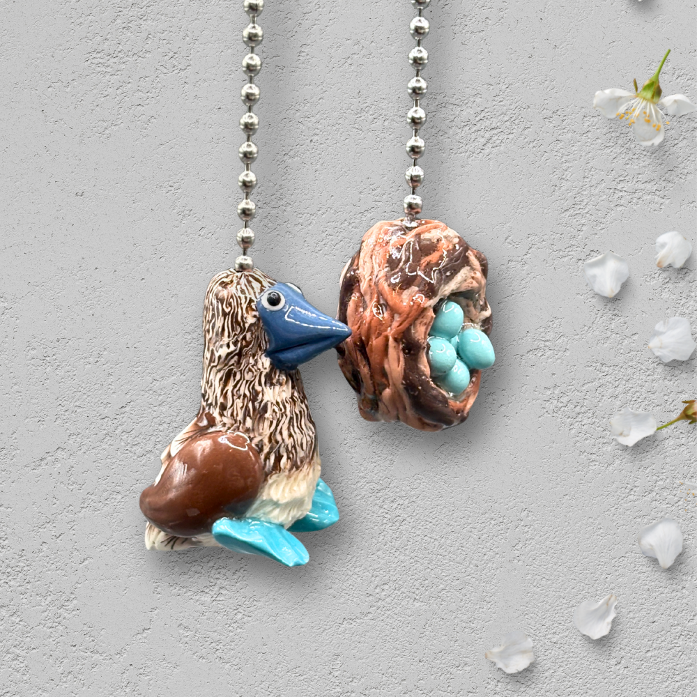 Two decorative ceiling fan pull chains with bird and nest design.