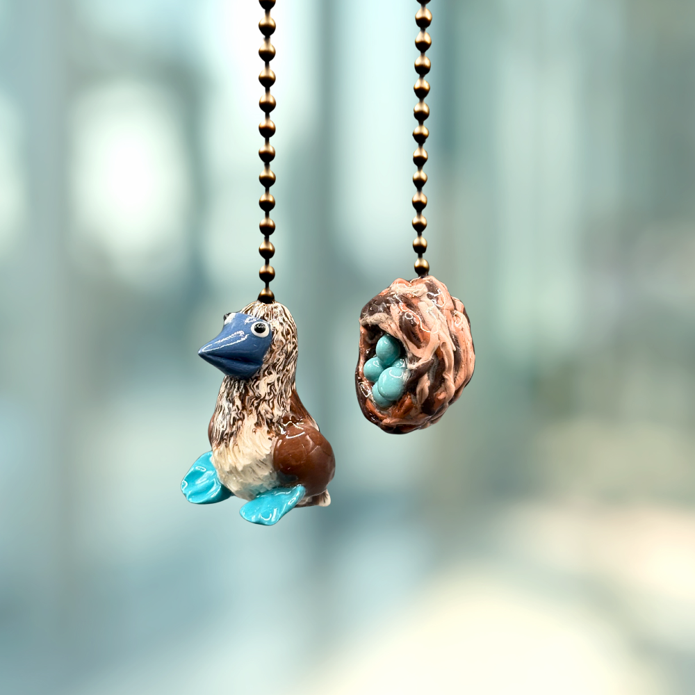 Two decorative ceiling fan pull chains with bird and nest design.