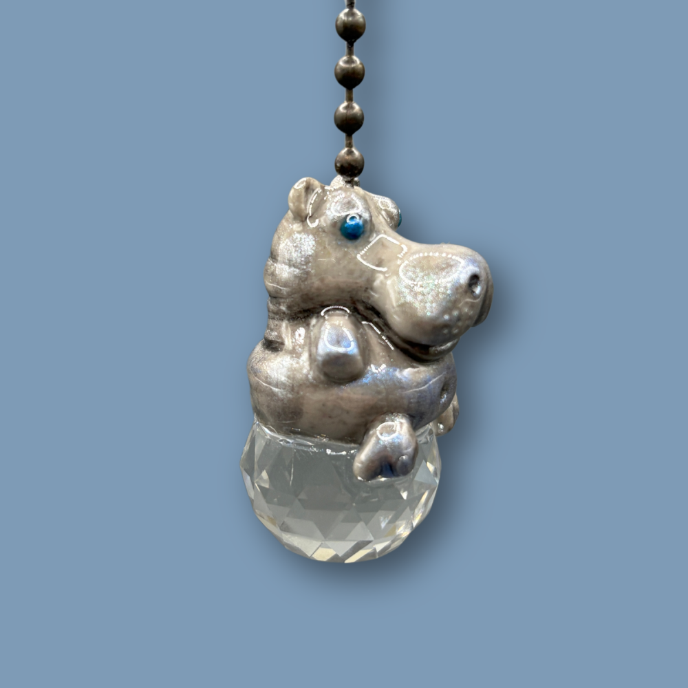 Hippopotamus light pull with crystal ball. Handmade with polymer clay. Hippopotamus is Grey colored with silver and metallic blue sheen sitting on a clear crystal ball