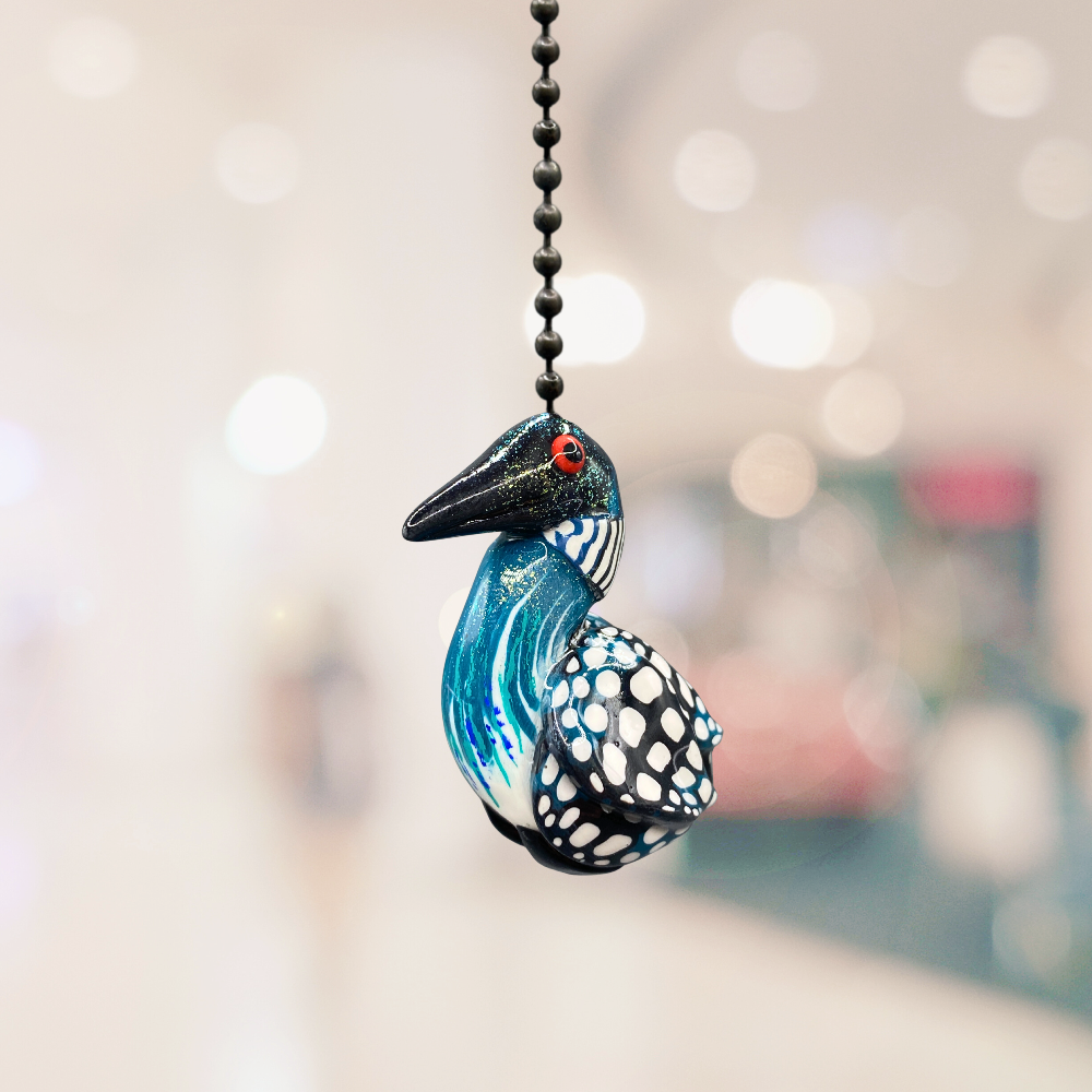 A handmade Loon charm used as a light or fan pull.