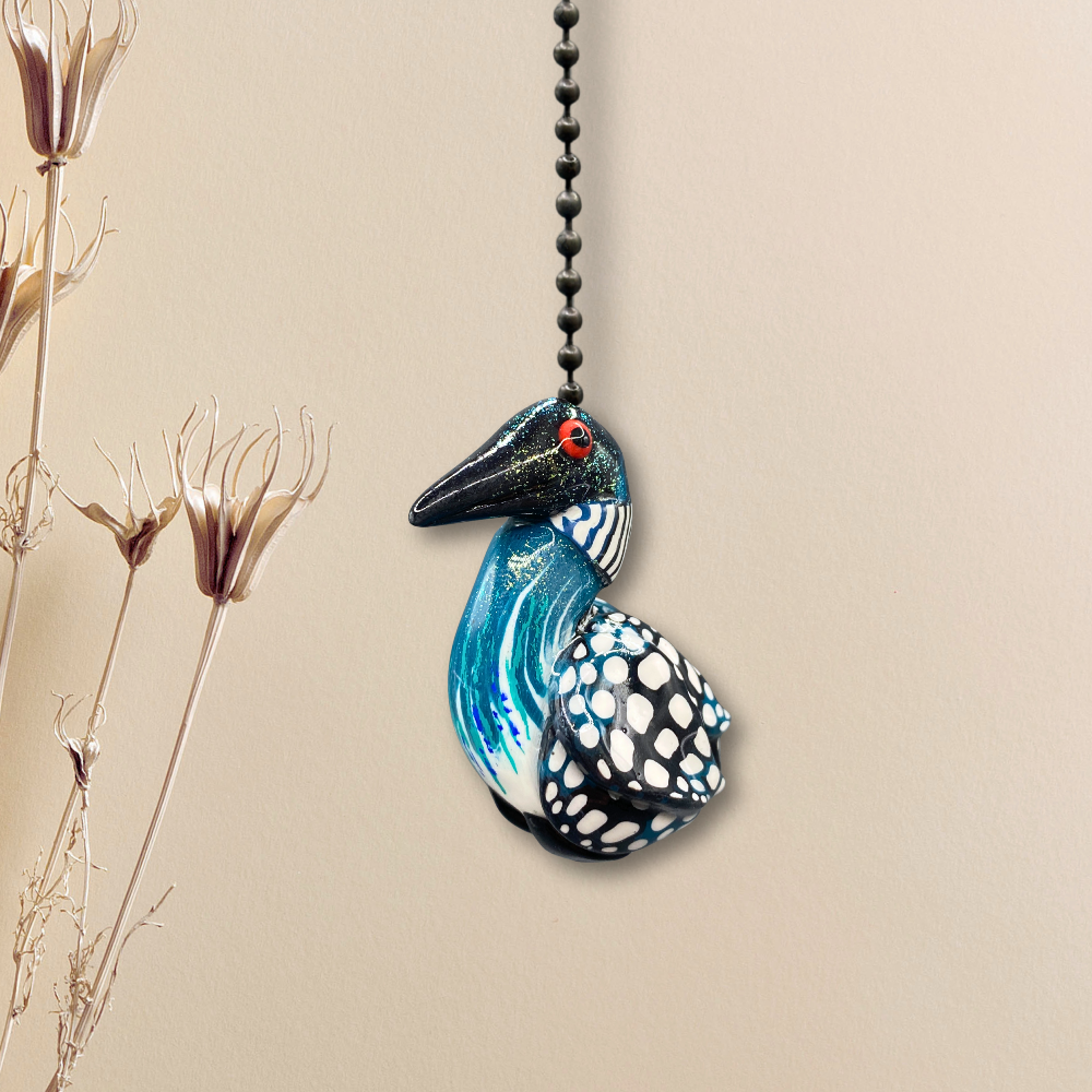 A handmade Loon charm used as a light or fan pull.