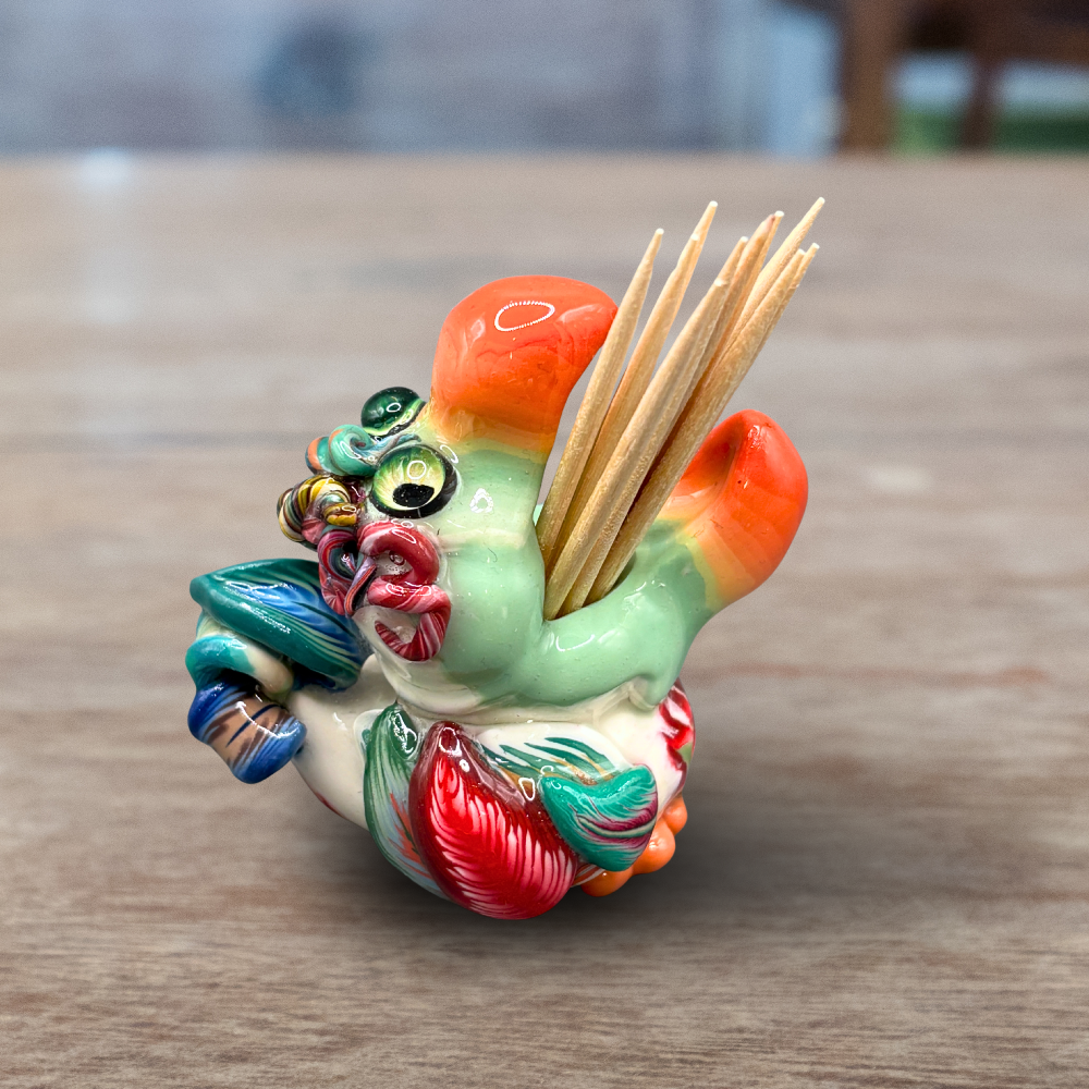 Colorful handmade polymer clay Dodo bird toothpick holder on a wooden surface