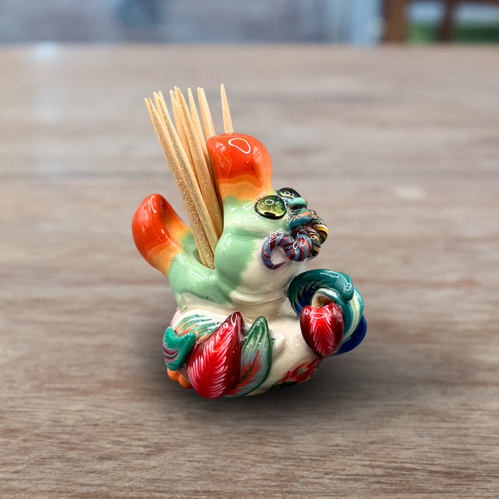 Colorful handmade polymer clay Dodo bird toothpick holder on a wooden surface