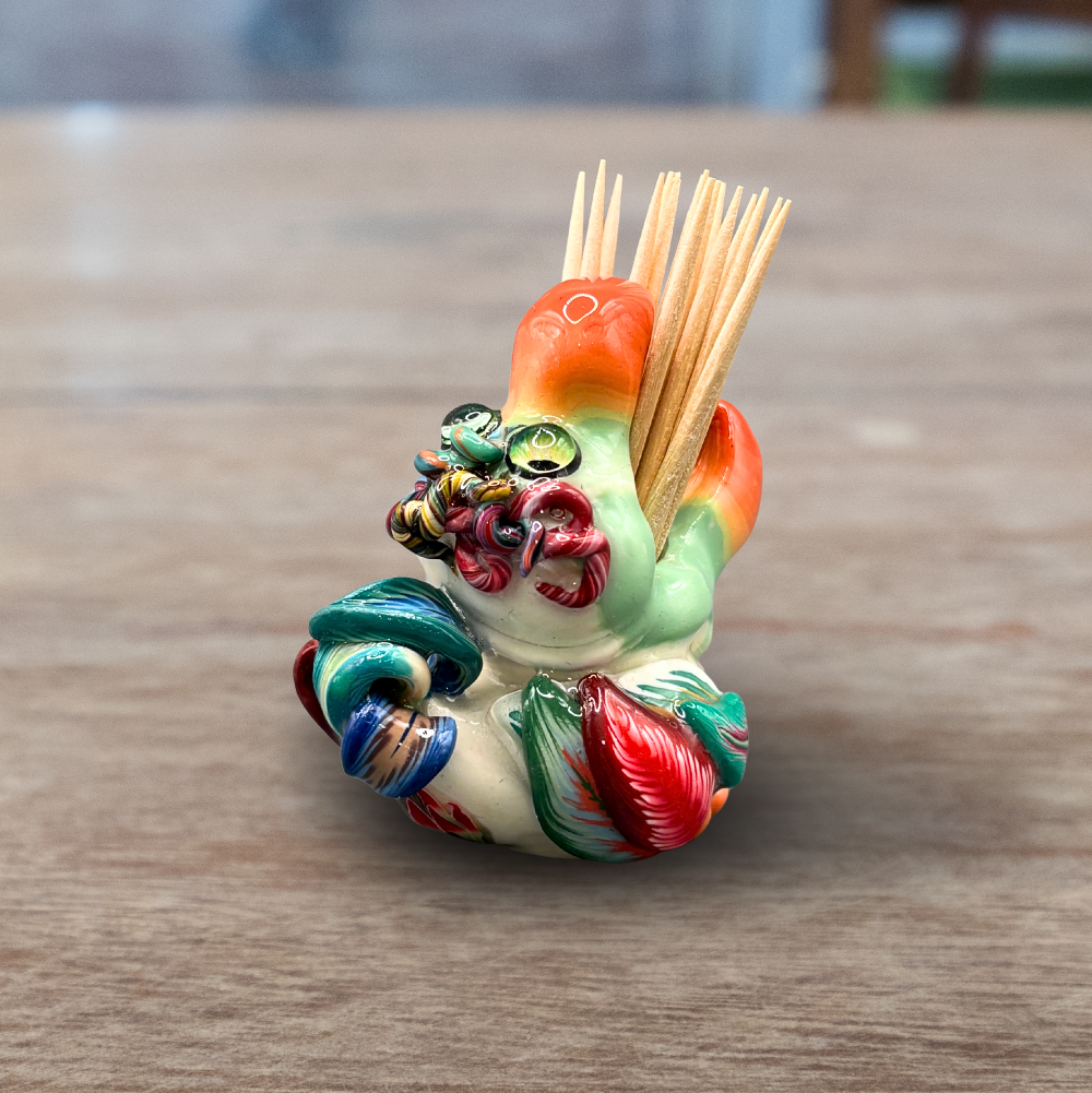 Colorful handmade polymer clay Dodo bird toothpick holder on a wooden surface