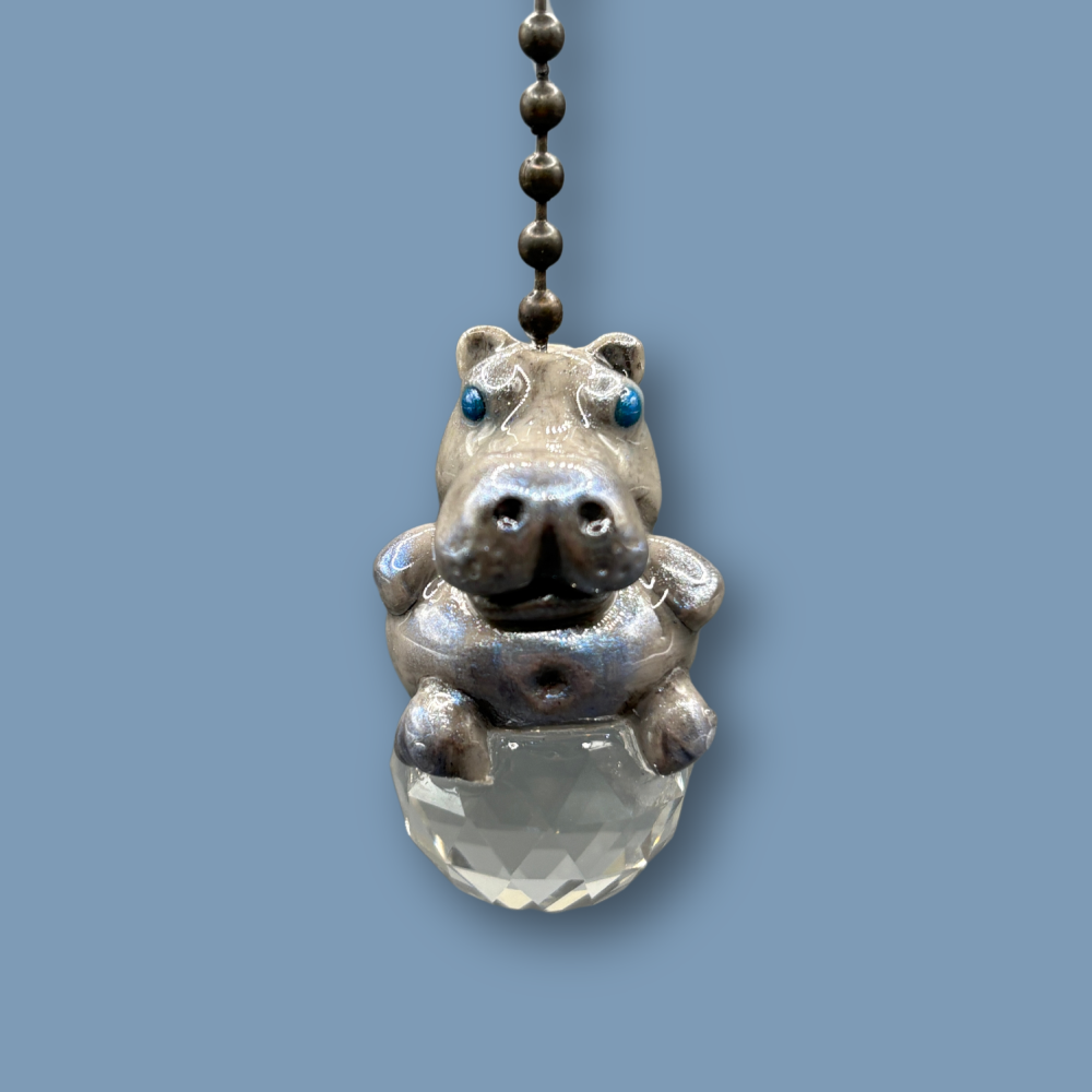 Hippopotamus light pull with crystal ball. Handmade with polymer clay. Hippopotamus is Grey colored with silver and metallic blue sheen sitting on a clear crystal ball 