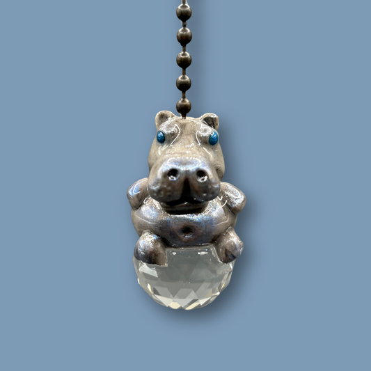 Hippopotamus light pull with crystal ball. Handmade with polymer clay. Hippopotamus is Grey colored with silver and metallic blue sheen sitting on a clear crystal ball 