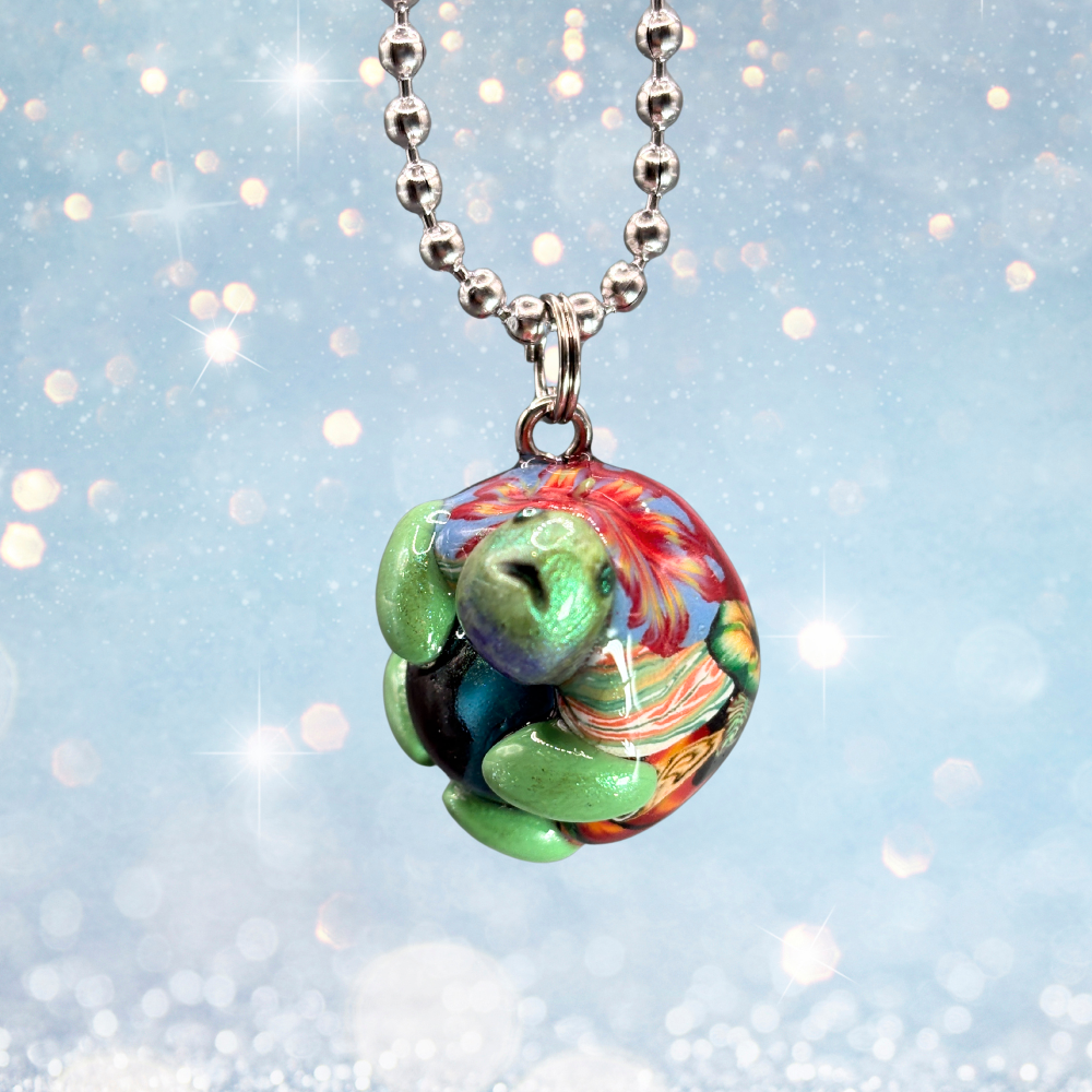 Green and red turtle car charm with a blue marble in its belly