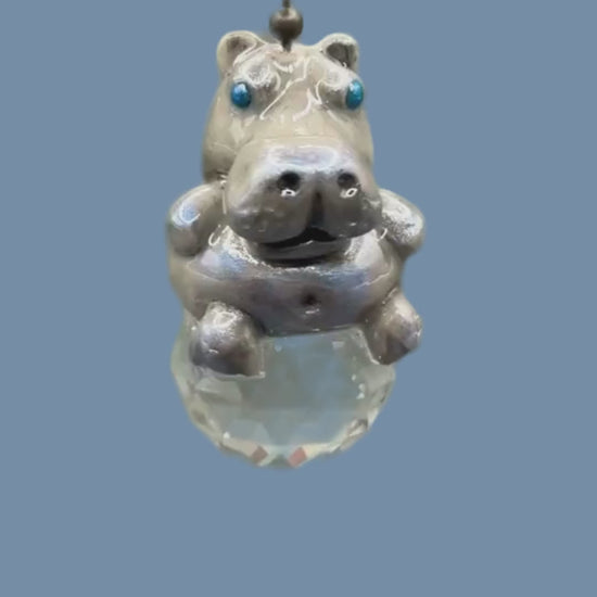 Hippopotamus light pull with crystal ball. Handmade with polymer clay. Hippopotamus is Grey colored with silver and metallic blue sheen sitting on a clear crystal ball 