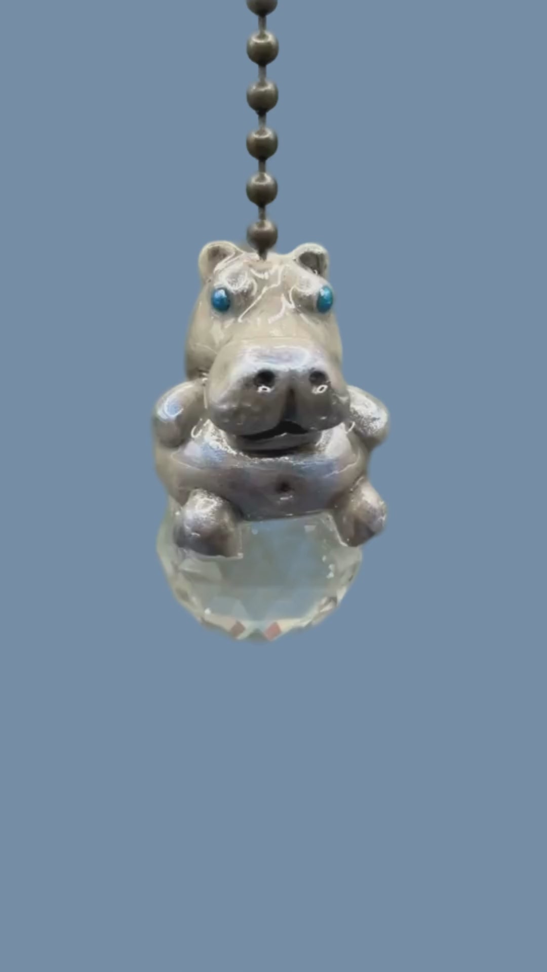 Hippopotamus light pull with crystal ball. Handmade with polymer clay. Hippopotamus is Grey colored with silver and metallic blue sheen sitting on a clear crystal ball 